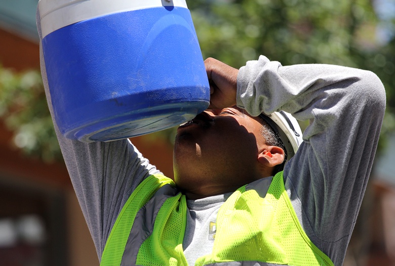 A construction worker, Moreno Garcia, drinking fluids